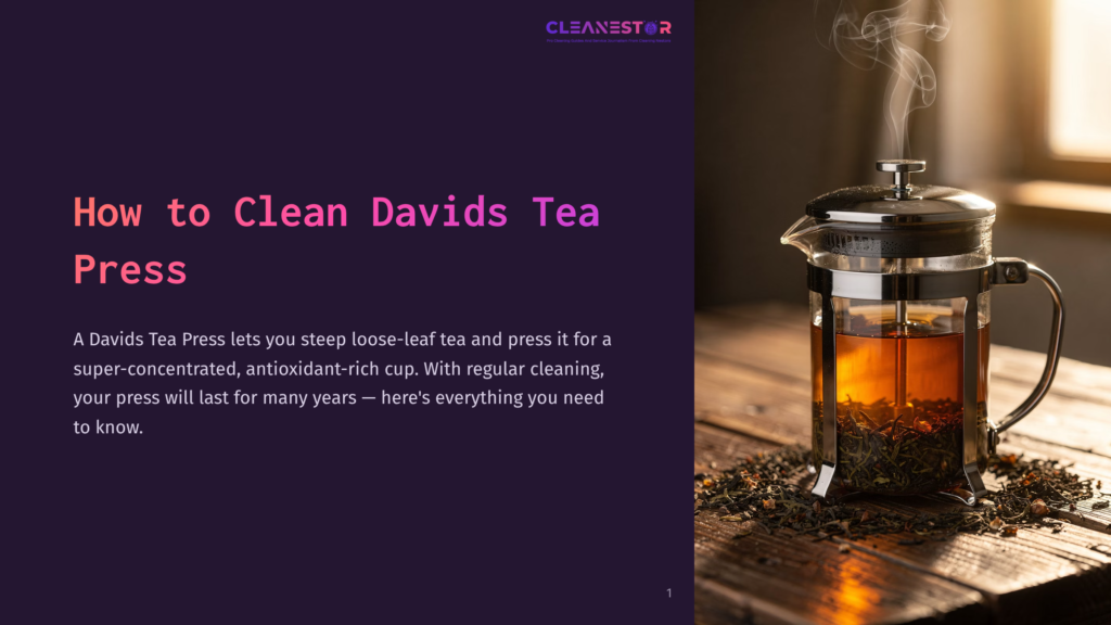 A Glass Davidstea French Press Filled With Dark Amber Tea And Loose Tea Leaves Sits On A Wooden Table, With Steam Rising From The Top.