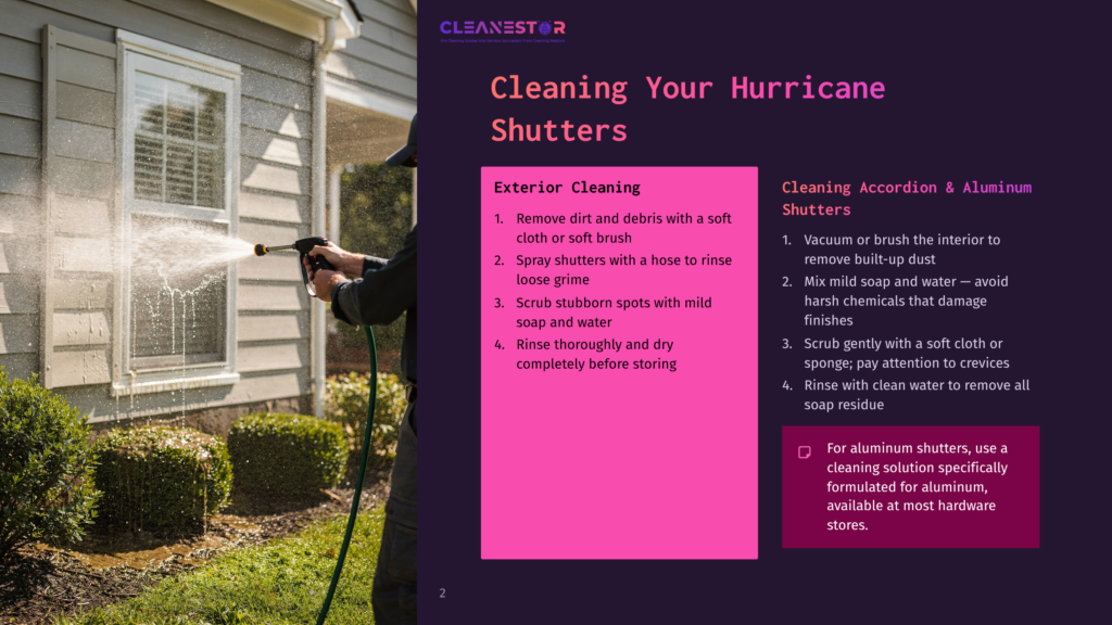 Cleaning A Hurricane Shutter With A Pressure Washer, Showing A Man Spraying Water On The Exterior Of A House With Green Bushes And A Window.