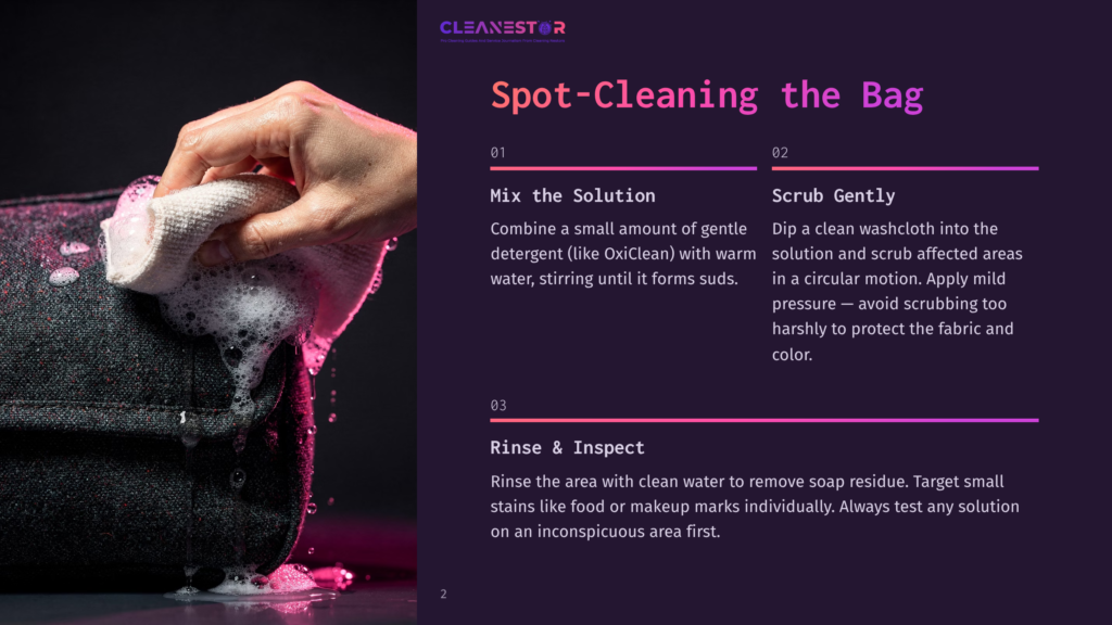 A Hand Gently Scrubs A Dark Fabric Bag With A Sudsy Washcloth, Demonstrating Spot-Cleaning Techniques For Fabric Bags.