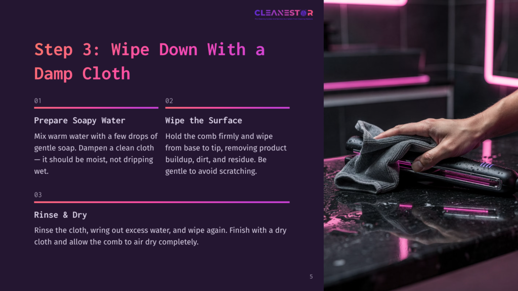 5 Step 3 Wipe Down With A Damp Cloth Step 3: Wipe Down With A Damp Cloth. A Hand Holding A Gray Microfiber Cloth Wipes A Black And Pink Hair Straightener On A Dark, Reflective Countertop.