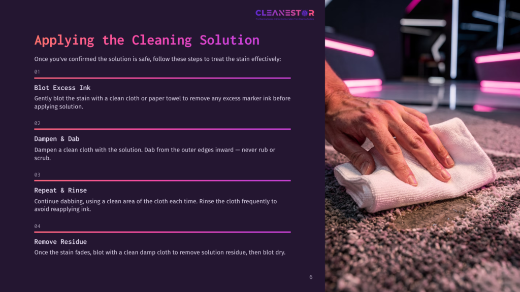 Close-Up Of Hands Gently Blotting A Dark Stain On A Textured Rug With A White Microfiber Cloth, Demonstrating A Cleaning Solution Application.