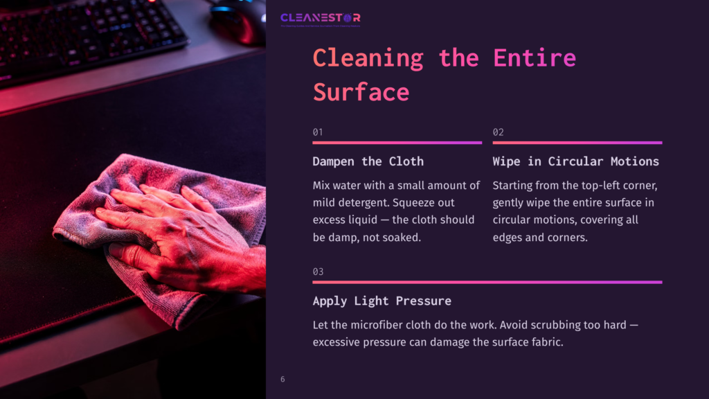 Close-Up Of Hands Gently Wiping A Dark Surface With A Microfiber Cloth, Illustrating Cleaning Steps From A Guide Titled &Quot;Cleaning The Entire Surface&Quot; With Text About Dampening The Cloth And Wiping In Circular Motions.