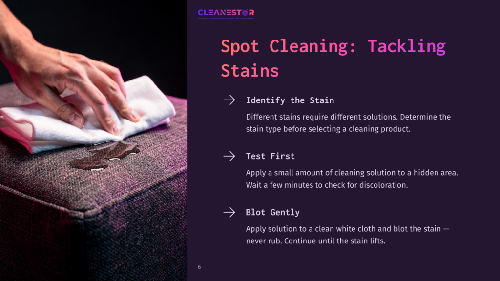 Close-Up Of A Hand Gently Blotting A Dark Stain On A Textured Upholstered Surface With A White Cloth, Illustrating Spot Cleaning Techniques.