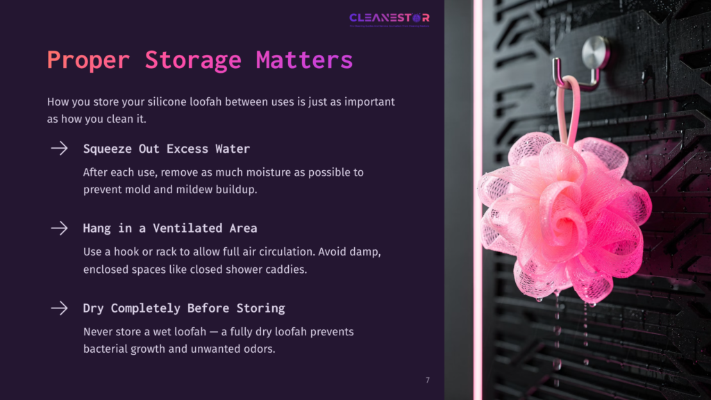 A Pink Silicone Loofah Hangs From A Hook On A Dark, Textured Wall, Illustrating Proper Storage Tips For Keeping Loofahs Clean And Hygienic.