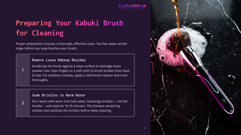 Close-Up Of A Kabuki Brush Being Cleaned, With Foamy Water Pouring Onto Its Pink And Purple Bristles Against A Dark Marble Background.