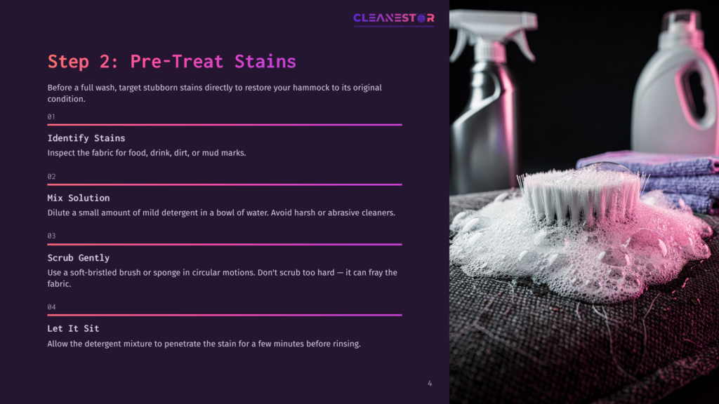 Close-Up Of A Cleaning Brush With White Bristles Covered In Pink Soap Suds, Resting On A Textured Dark Fabric. In The Background, Cleaning Spray Bottles And Folded Purple Towels Are Blurred.