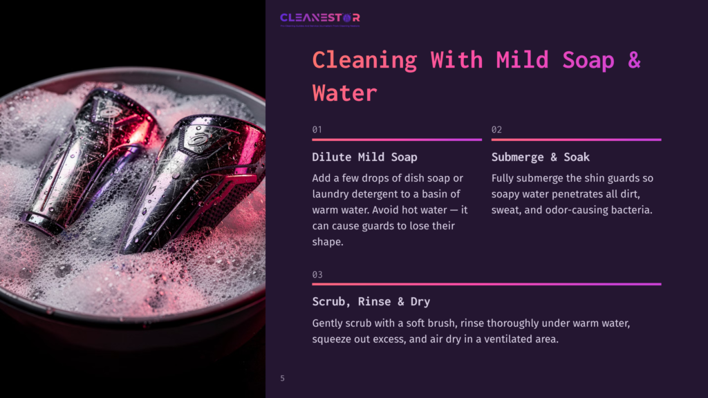 5 Cleaning With Mild Soap And Water Two Shiny, Metallic Shin Guards Are Submerged In Soapy Water With Bubbles, Ready For Cleaning. Text Overlay Reads &Quot;Cleanestor Cleaning With Mild Soap &Amp; Water&Quot;.