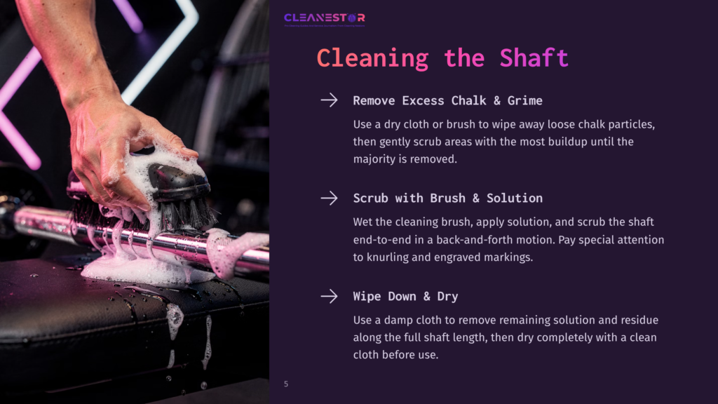 5 Cleaning The Shaft A Hand Holding A Scrub Brush Cleans A Barbell Shaft, With Chalk And Residue Visible. Background Features A Dark Gym Setting.