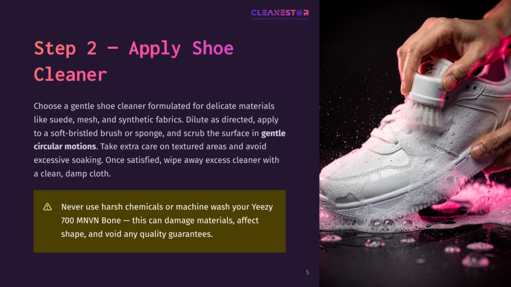 Close-Up Of A Hand Using A Soft Brush To Clean A White Sneaker With Foam, Illustrating The Shoe Cleaning Process Described On The Dark Purple Background.
