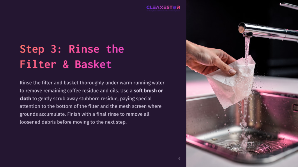 A Hand Rinses A Coffee Filter And Basket Under Warm Running Water, With Soap And Cloth Nearby. Background Features A Sink And Reflective Surface.