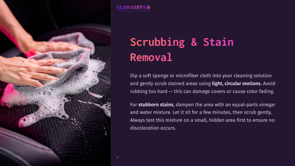 Hands Scrub A Car Seat With A Microfiber Cloth And Cleaning Solution, Creating Foam. The Text &Quot;Cleanestor&Quot; And &Quot;Scrubbing &Amp; Stain Removal&Quot; Is Visible.