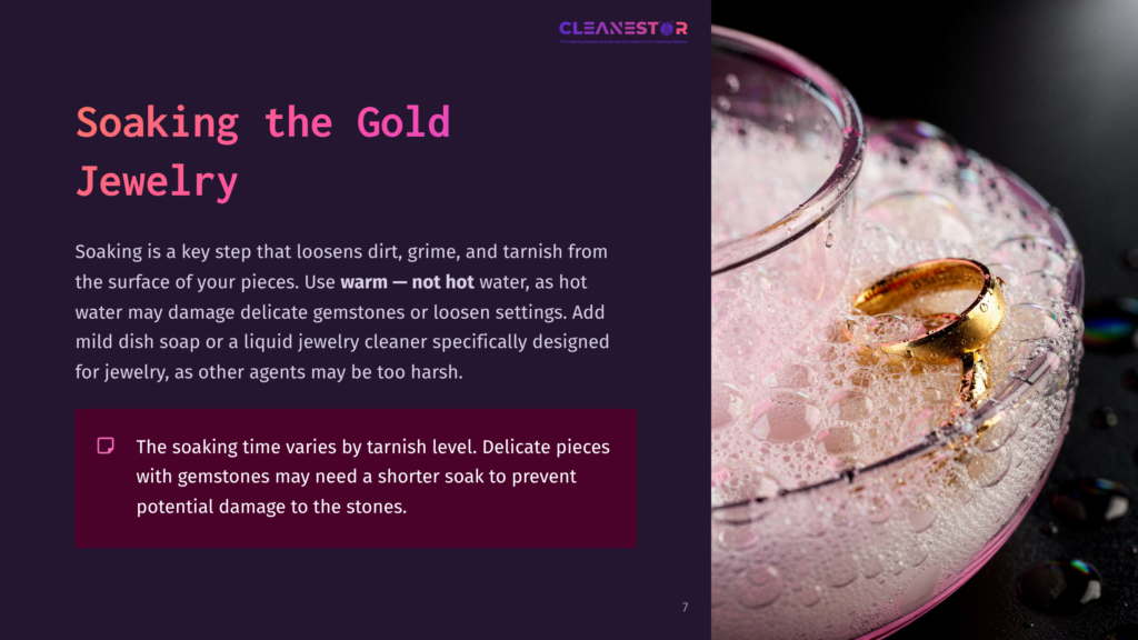 A Gold Ring With A Diamond Soaks In A Dish Of Soapy Water, With Bubbles And Water Droplets Visible.