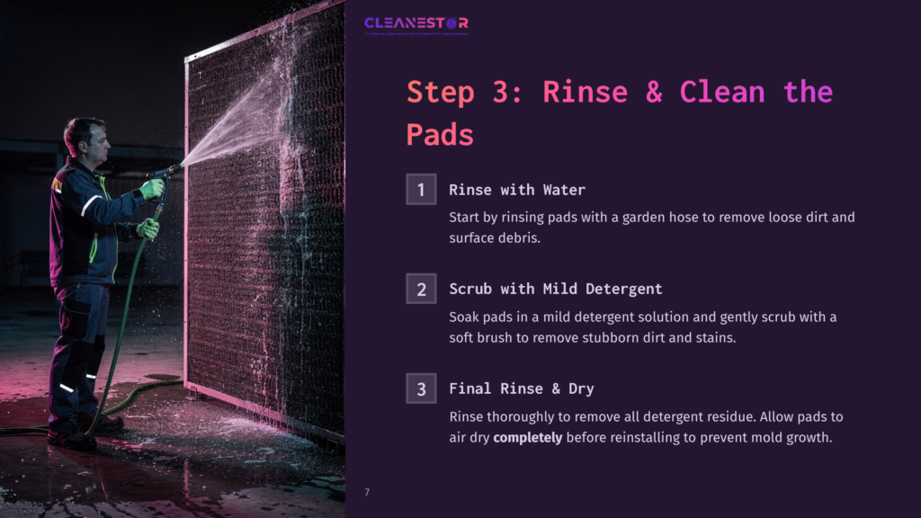 7 Step 3 Rinse And Clean The Pads A Man In A Blue Uniform Sprays Water From A Hose Onto A Large, Dark-Colored Cooling Tower Coil. Text On The Image Reads: &Quot;Cleanestor&Quot;, &Quot;Step 3: Rinse &Amp; Clean The Pads&Quot;, And Provides Numbered Instructions For Rinsing And Scrubbing.
