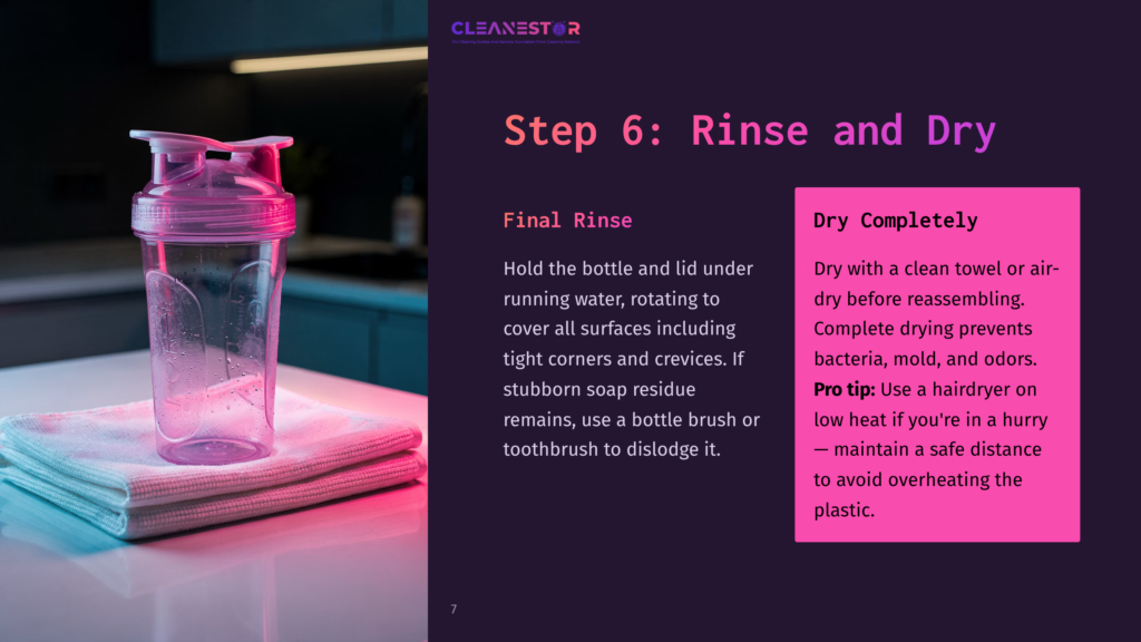 Transparent Blender Bottle With A Pink Lid And A Glossy Finish, Placed On A White Surface With A Towel, Under Soft Lighting.