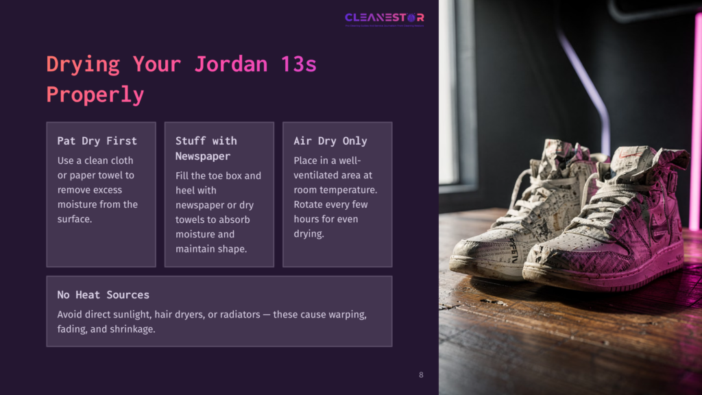 Two High-Top Jordan 13 Sneakers, One Upright And One Tilted, Sit On A Wooden Surface. The Sneakers Are Covered In A Newspaper Print Pattern, With Visible Text And Images. The Background Is Blurred, Suggesting An Indoor Setting.