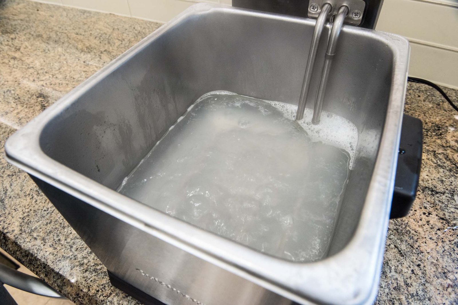 A clean turkey fryer pot with a person wiping it down